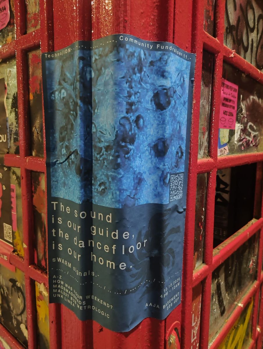 The sWARM signals 11 poster wrapped around a red phone box covered in stickers.